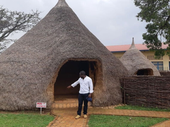 man pointing to sign next to large cone structure